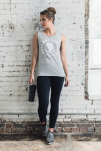 Woman wearing a light gray muscle tank with athletic leggings