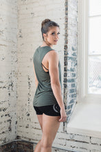 Fit woman wearing an olive green muscle tank and black shorts
