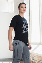 Women in black lift or leave tee and gray athletic leggings
