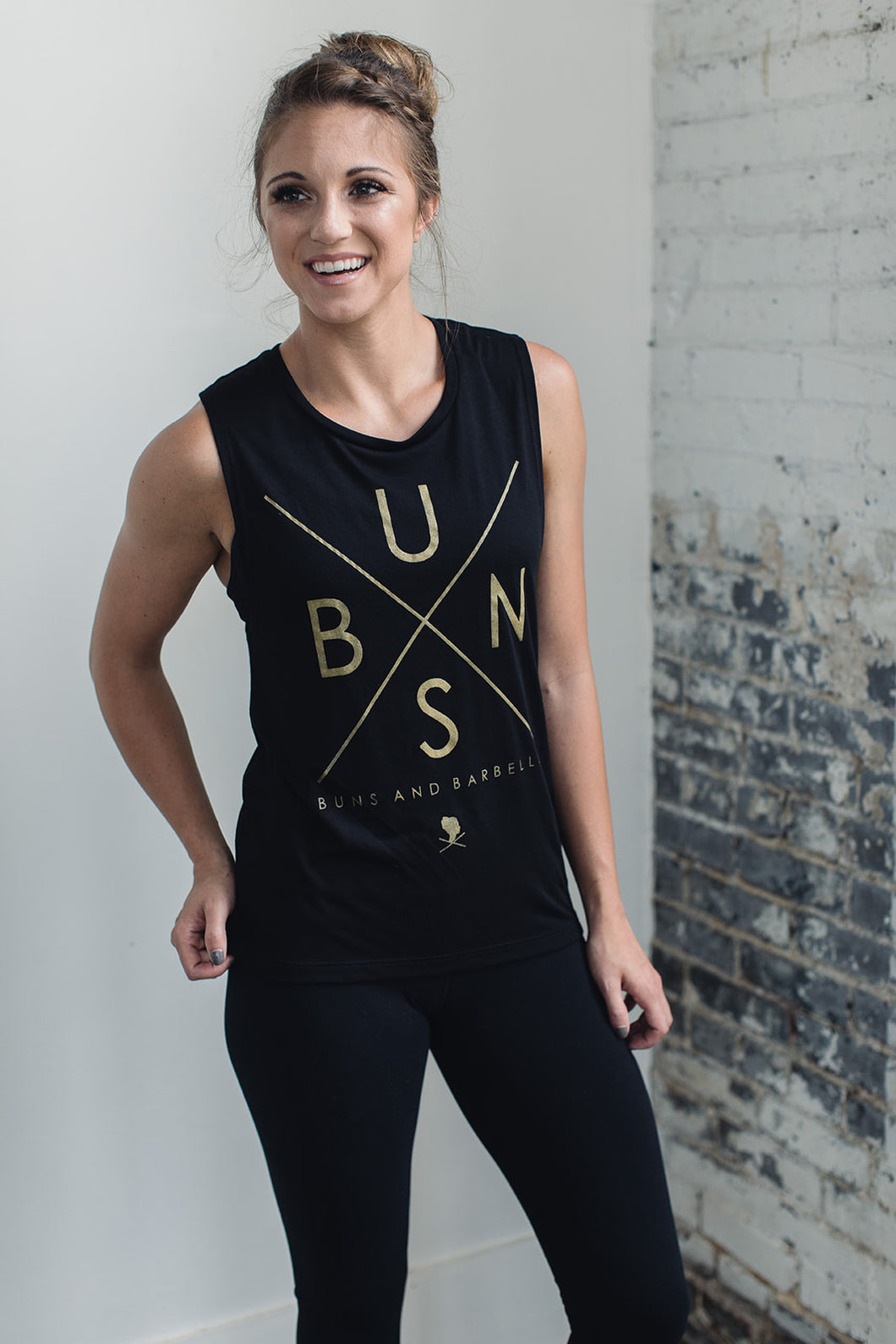 Athletic woman wearing a black muscle tank with a graphic on front