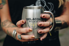stainless steel mug in tattooed woman's hands
