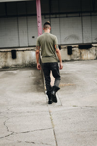man walking away wearing a fitted olive tee