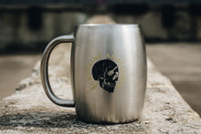stainless steel coffee mug sitting on concrete surface