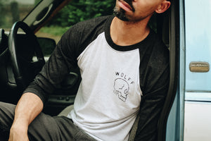 man in truck wearing a black and white baseball tee with skull graphic