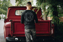 man next to a vintage red truck wearing a long sleeve black graphic tee