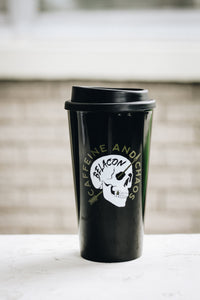 black travel mug with a skull design that says caffeine and chaos