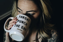 woman drinking out of a mug that says throat punch the day