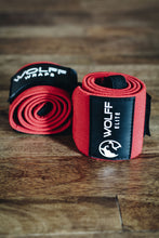 red wrist wraps laying on a hardwood floor