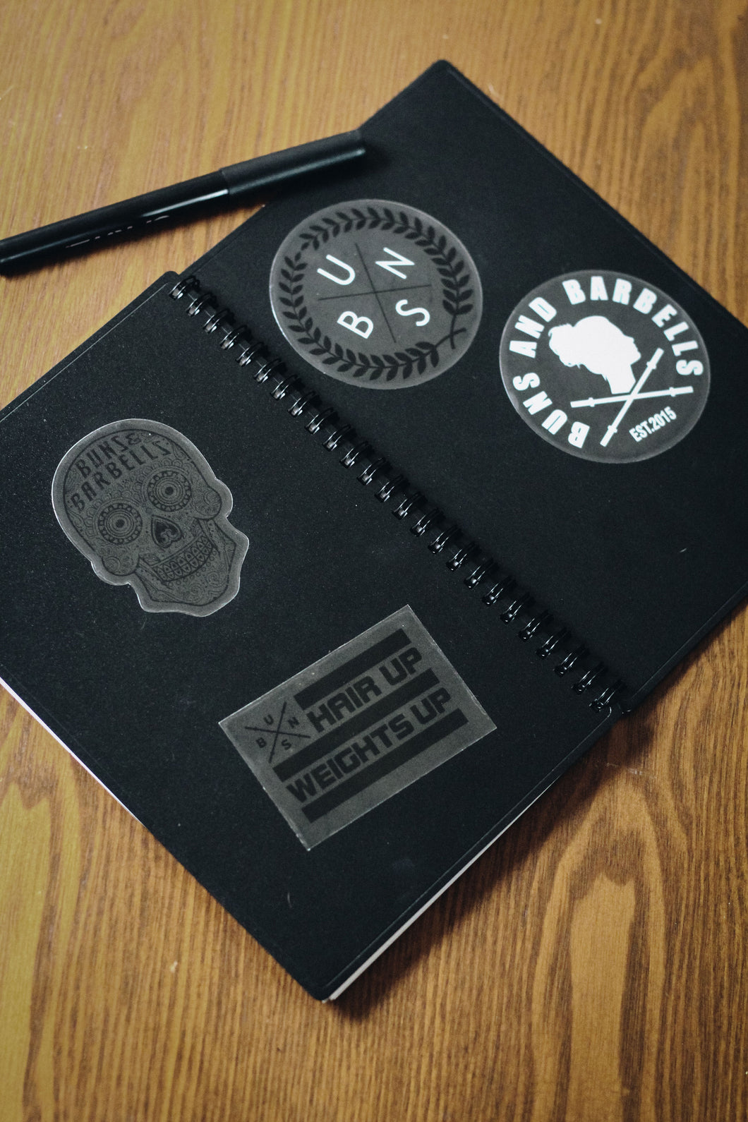 stickers on a black notebook with pen