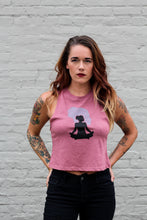 tattooed woman wearing a mauve crop top tank with a yoga graphic design