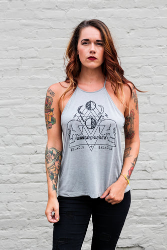 tattooed woman wearing a high neck tank with moons and skulls