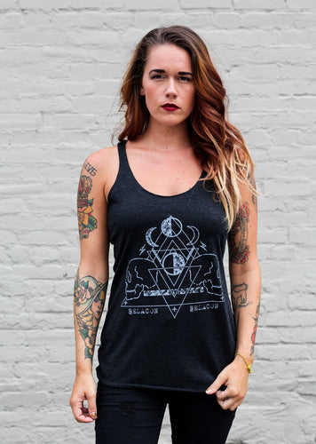 tattooed woman wearing black tank top with skull graphic design