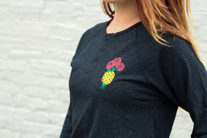 pineapple and rose graphic design on the pocket of a long sleeve henley shirt