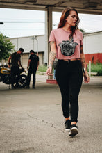 Woman walking while wearing a mauve crop top with a hamsa design