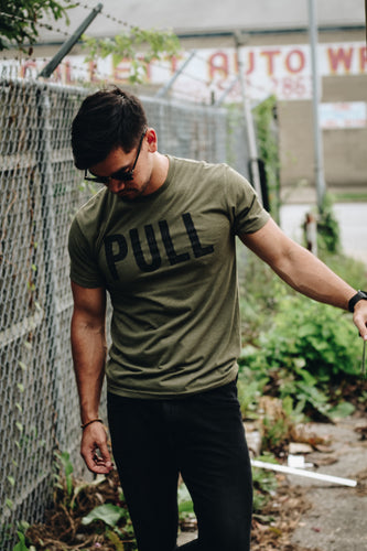 Athletic man wearing an olive green fitted tee
